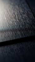 Close-up macro shot of dark textured fabric surface with fine weave pattern and soft lighting creating depth and shadow details for textile design projects.