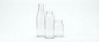 Empty clear glass bottles of different sizes arranged in row on white background isolated for packaging design and product mockup.