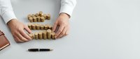 Male hands arranging cork pieces on white surface, representing business strategy, planning, and organizational concepts for corporate training and development materials.