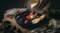 Fresh autumn fruits with honey being poured from wooden spoon into dark bowl on rustic table with dramatic lighting for food photography and cooking.