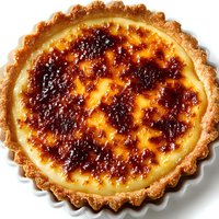 Homemade creme brulee tart with caramelized sugar topping and fluted pastry crust isolated on white background for culinary and dessert design projects.