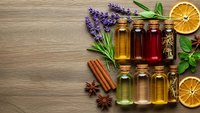Essential oils collection with lavender, herbs and citrus on wooden background for aromatherapy wellness and natural healing treatments.