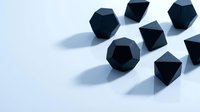 Black matte geometric polyhedron shapes arranged on white surface with soft shadows, modern minimalist design concept for backgrounds.
