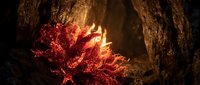 Glowing red crystal formation with fiery light emanating from rocky cave walls creating mystical underground atmosphere for fantasy gaming backgrounds.