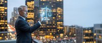 Senior businessman holding glowing scales of justice hologram against city skyline at dusk, representing legal technology and corporate law services.