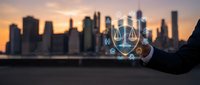 Professional businessman holding glowing digital justice scales icon against urban skyline at sunset for legal technology and law firm concepts.