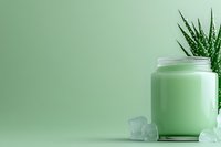 Fresh mint smoothie in glass jar with ice cubes and aloe vera plant on green background, healthy lifestyle concept for wellness blogs and social media.