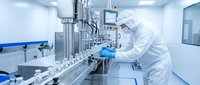 Pharmaceutical technician in protective suit working with automated production line in sterile cleanroom laboratory for drug manufacturing and quality control.