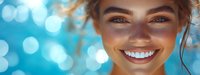 Young woman with freckles and bright smile against blue bokeh background, radiating happiness and confidence in summer atmosphere.
