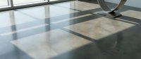 Modern polished concrete floor with natural sunlight casting geometric window shadows creating abstract patterns in minimalist interior space.