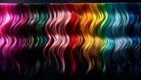Vibrant wavy hair strands in rainbow colors from pink to turquoise on black background, showcasing different hair dye trends and color possibilities for salon inspiration.