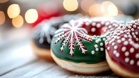 Festive holiday donuts with intricate snowflake decorations in red and green frosting on wooden table with bokeh lights in background.