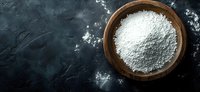 White flour in wooden bowl on dark textured background, baking ingredient for homemade bread, pastry, and dessert recipes.