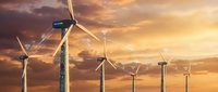 Wind turbines generating clean renewable energy against dramatic sunset sky with golden clouds creating sustainable power landscape.