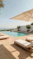 Luxury poolside terrace with wooden sun loungers and beige umbrella overlooking scenic landscape for vacation resort hospitality and summer relaxation concepts.
