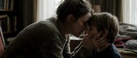 Tender moment between a Caucasian mother and young son touching foreheads in a cozy bedroom, expressing love, care, and emotional family bond.