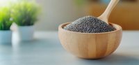 Fresh black poppy seeds in wooden bowl with spoon on light gray table, selective focus with blurred background, healthy organic superfood ingredient.