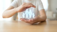 Protective hands surrounding glowing family silhouette symbolizing insurance coverage, security and care for loved ones in modern home setting.