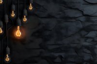 Glowing vintage Edison bulbs hanging against dark textured wall create moody atmospheric lighting with dramatic shadows and warm illumination.