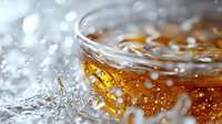 Refreshing cola or whiskey drink with ice cubes in glass, splashing liquid and condensation droplets on surface, perfect for beverage advertising and food photography.
