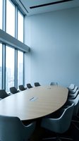 Modern corporate boardroom with oval conference table and executive chairs overlooking city skyline through floor-to-ceiling windows for business meetings.