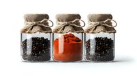 Glass jars with burlap tops containing black peppercorns and red paprika powder arranged in row on white background, isolated spice containers for cooking and seasoning.