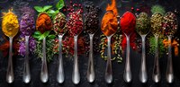 Colorful spices and seasonings arranged in vintage silver spoons on dark background, vibrant food ingredients with peppercorns and fresh herbs for cooking.