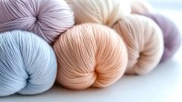 Soft pastel colored yarn skeins in gentle hues of blue, peach, and lavender arranged for crafting and knitting projects on white background.