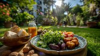 Fresh Mediterranean lunch with roasted vegetables, microgreens, bread, and olive oil in sunny garden setting, perfect for outdoor dining.