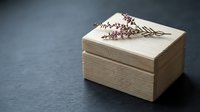 Wooden jewelry box with dried lavender flowers on dark surface for romantic gift storage and home decor styling.