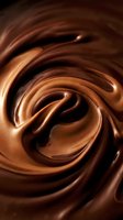 Swirling melted chocolate with rich brown tones and glossy highlights creates an abstract spiral pattern. Use for confectionery, dessert, food packaging, and culinary marketing materials.
