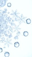 Crystalline snowflakes and water droplets arranged on white background, suitable for winter, holiday, and seasonal design projects.