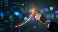Businessman hand pointing upward arrow with glowing light effect against blurred city lights background showing growth success and financial progress.