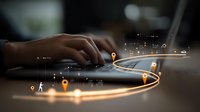 Person using laptop with digital map overlay showing glowing navigation route with location pins and data points for travel planning or logistics management.