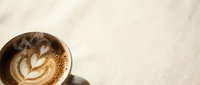 Coffee cup with latte art foam design on marble surface, morning beverage concept for cafe menu and restaurant branding materials.