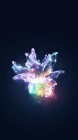 Luminescent flower with translucent petals glowing in rainbow colors against dark background, creating magical ethereal effect with sparkling light particles.