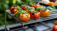 Fresh persimmons grilled with herbs and spices on metal cooking rack, vibrant orange fruits with charred tops and green garnish, selective focus food photography.
