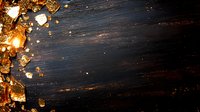 Golden light fragments and sparkles scattered on dark wooden background with dramatic lighting and copy space for text or design elements.