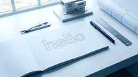 Architect desk with graph paper notebook showing hello text, ruler, compass, pen, blueprints, and house model in blue tones.