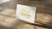 Elegant gold foil Happy Birthday greeting card on rustic wooden table surface for celebration and special occasion design projects.