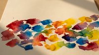 Colorful watercolor paint splatters and brushstrokes on textured paper creating vibrant artistic background for creative projects and design work.