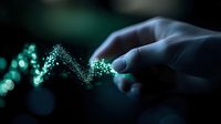 Glowing green particles forming a wave pattern float between fingers in dark background with bokeh lights, creating magical ethereal atmosphere.
