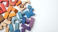 Colorful wooden building blocks scattered on white background, educational toys for children development and creative play activities.