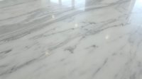 White marble floor with gray veining in modern interior space with natural lighting and polished surface finish for luxury home design.