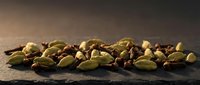 Scattered roasted pistachios with shells on dark stone surface, ideal for food photography, culinary content, and healthy snack marketing materials.