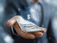 Business professional holding cash money with glowing digital dollar symbol hologram, representing financial technology and digital payment innovation.