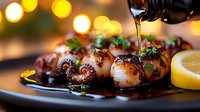 Grilled octopus tentacles drizzled with olive oil and garnished with fresh herbs and lemon on dark plate against blurred warm bokeh lights background.