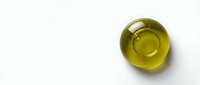 Golden olive oil in glass bowl on white background for cooking and culinary applications.