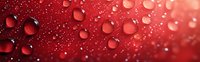 Red water drops on glass surface with blurred background creating romantic atmosphere and bokeh effect in panoramic format, macro photography.