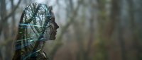 Young African American woman profile silhouette with double exposure forest trees overlay creating artistic nature connection concept for mindfulness meditation.